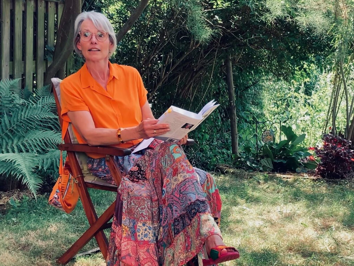 Katrien Jacobi im Gartenstuhl liest aus ihrem Buch vor